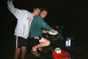 Max and Corey, two friends cooking while camping