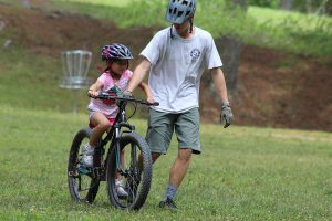 young girl learning to ride mountain bike