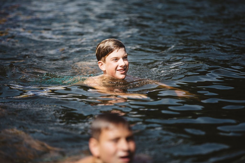 young boys swimming in lake