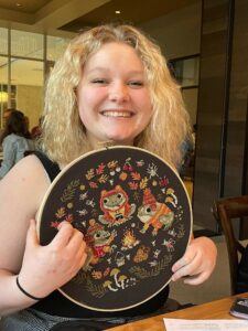 girl holding crosstich craft